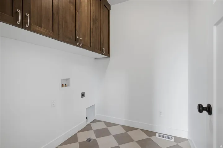 Built-in upper cabinetry with silver-tone hardware, checkered tile flooring, and white baseboards