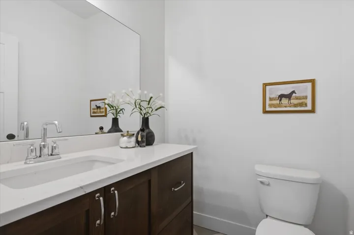 Dark wood-finish vanity with chrome hardware, an integrated white sink, and a white countertop