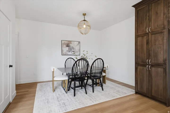 Light wood-finish flooring, white walls, and a built-in dark wood cabinetry