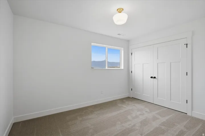 Carpeted flooring, white walls, and a window with mountain scenery