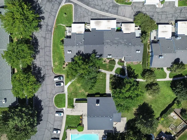 Community with mature trees, paved roadways, and a swimming pool