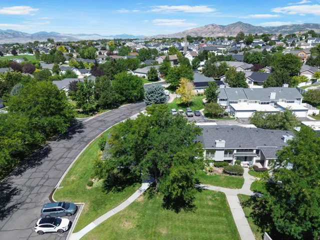 Residential area with mountain backdrop, mature trees, and paved streets