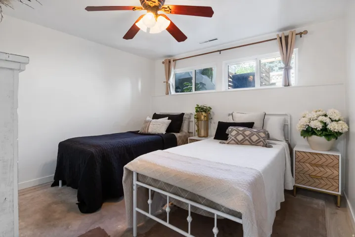 Wood-finish flooring, white walls, and a ceiling fan with integrated lighting