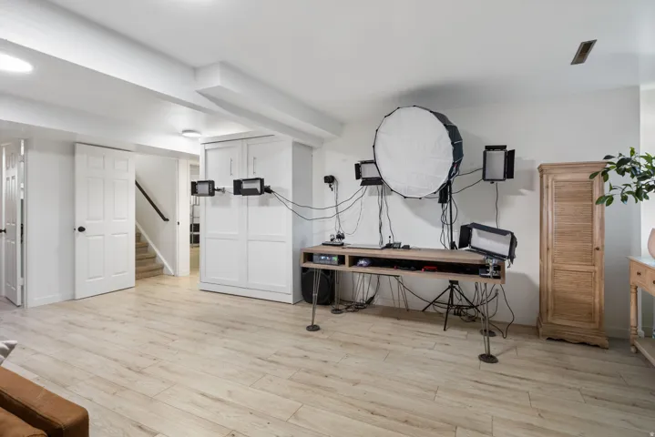 Recessed lighting, wood-finish flooring, white panel doors, and built-in white cabinetry