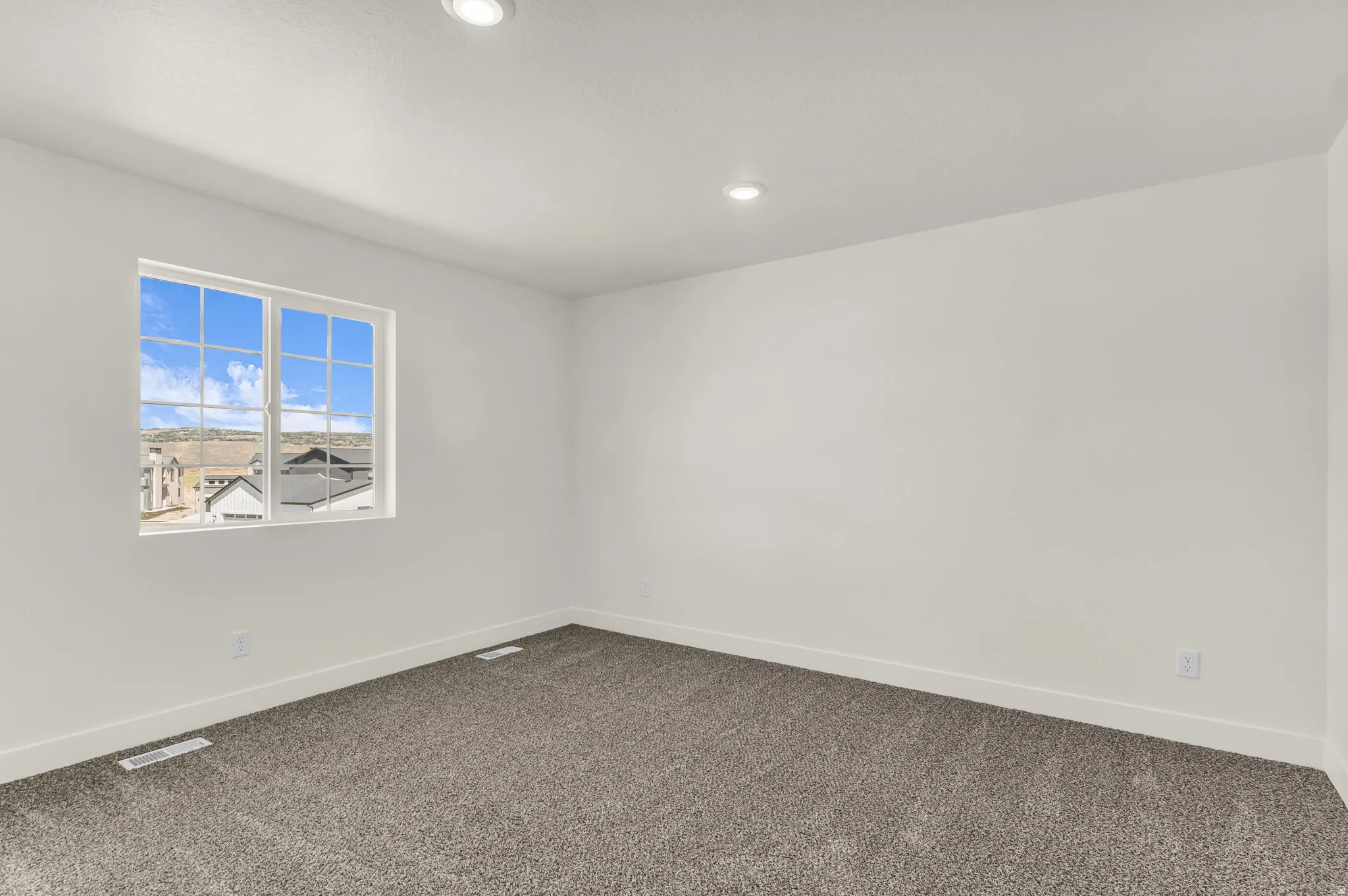 Neutral wall paint, recessed lighting, and gray carpet flooring