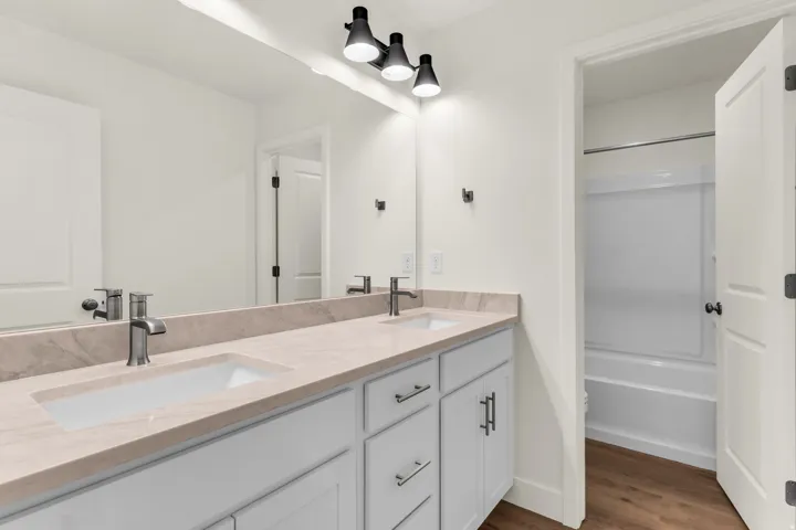 Dual vanity with undermount sinks, stone-finish countertop, and dark-finish hardware