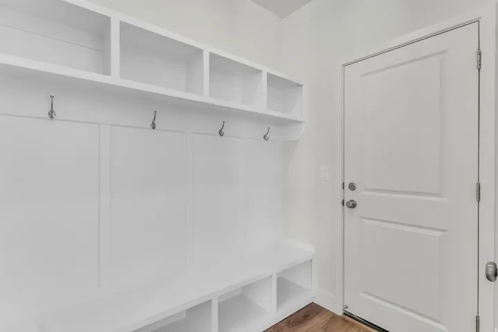 Built-in storage solutions featuring open shelving, storage cubbies, and wall-mounted hooks