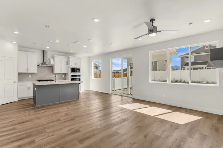 Open concept living area featuring wood-finish flooring, recessed lighting, and a modern ceiling fan