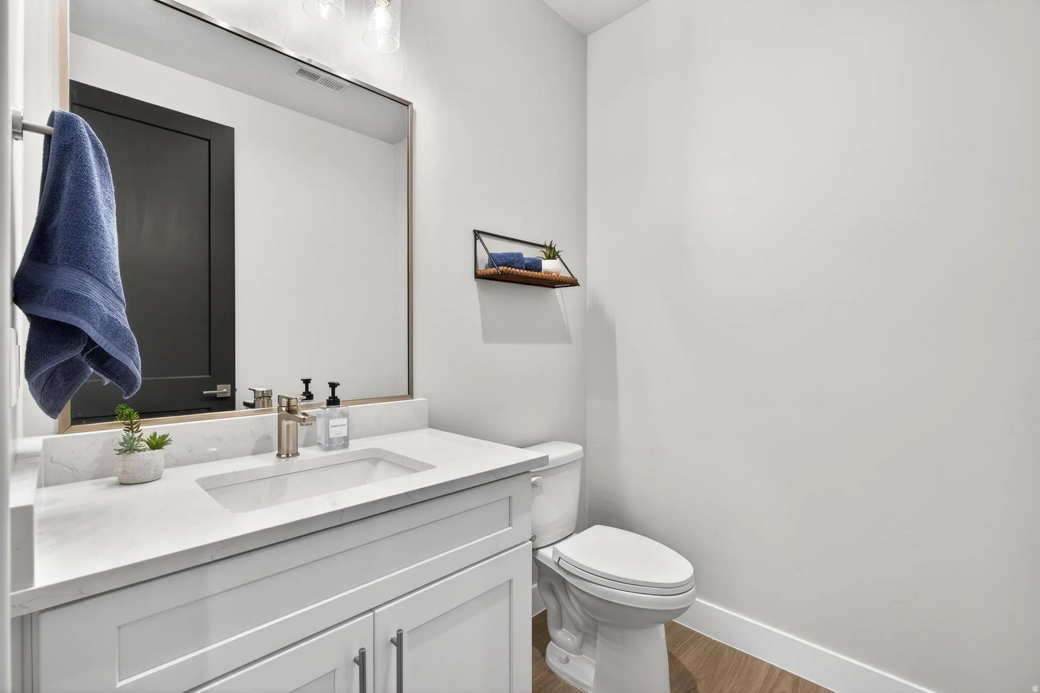 White vanity with shaker-style cabinetry, an integrated sink, and brushed nickel fixtures