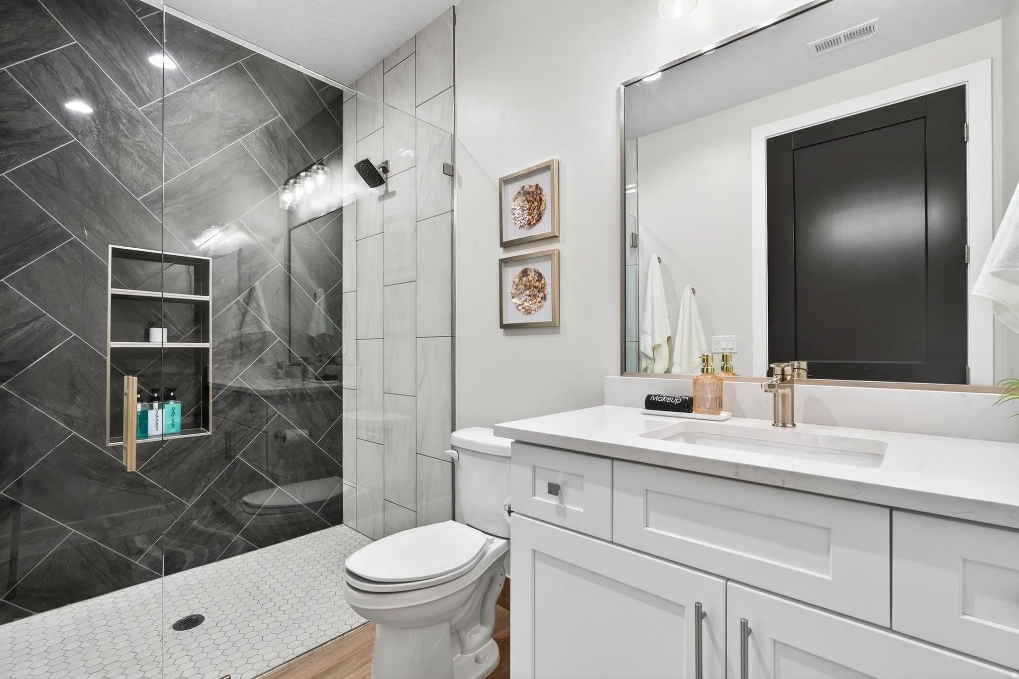 Tiled shower with a built-in niche, glass enclosure, and modern shower fixtures