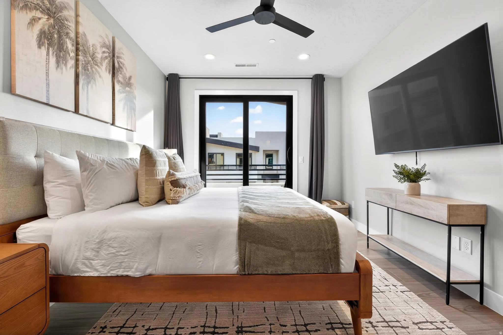 Recessed lighting, ceiling fan, wood-finish flooring, glass door, and a built-in wall-mounted television