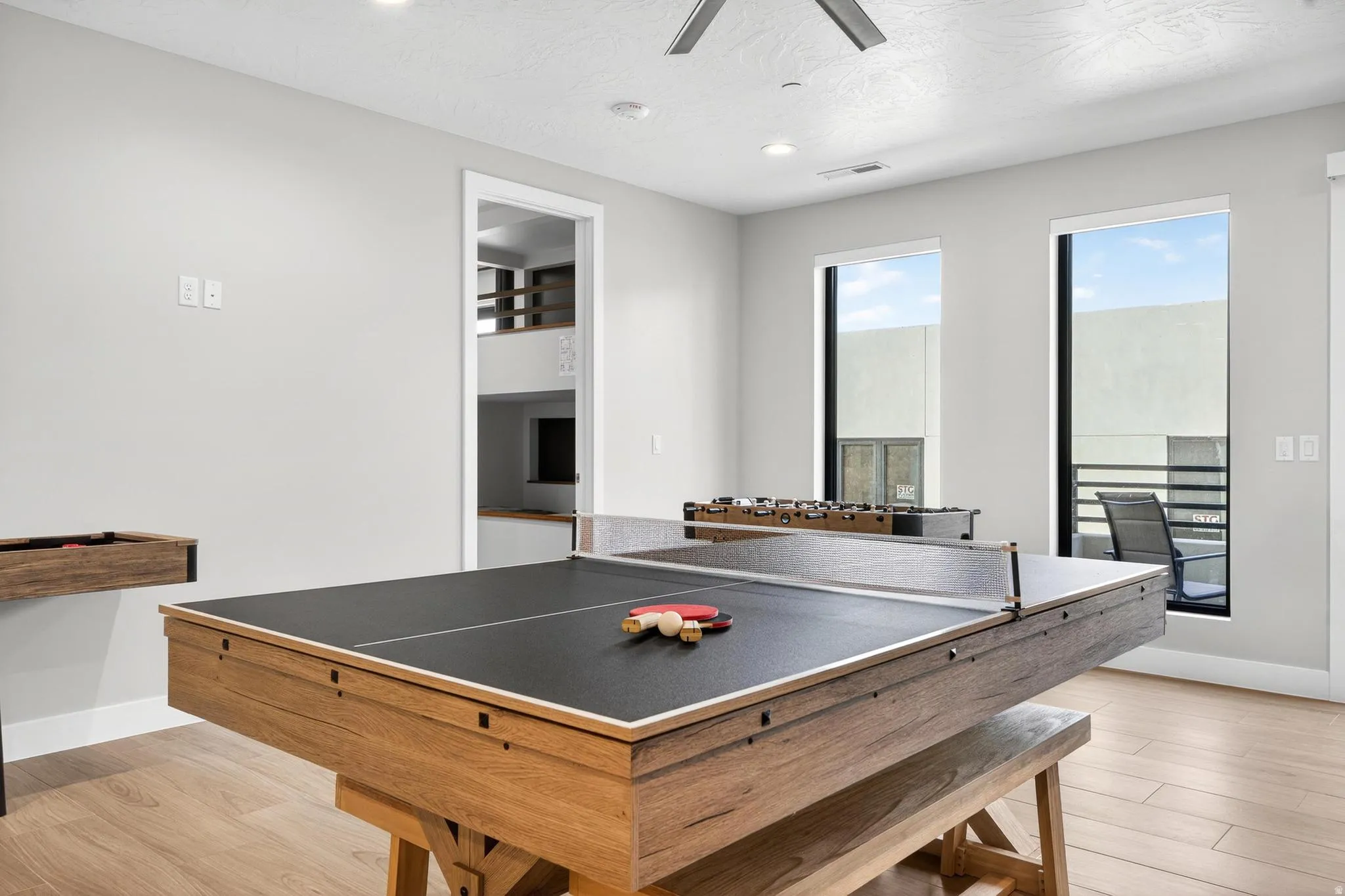 Entertainment room featuring recessed lighting, wood-finish flooring, and multiple windows