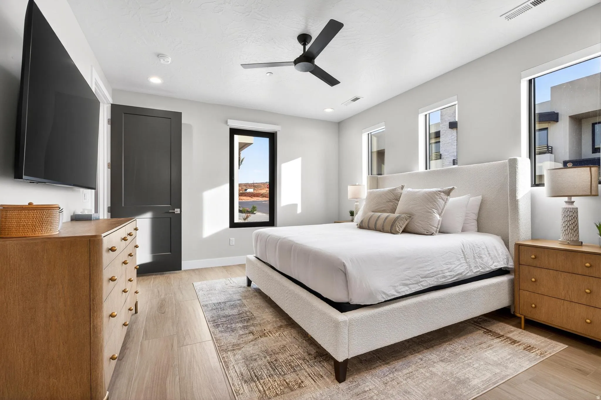 Wood-finish flooring, recessed lighting, ceiling fan, and multiple windows