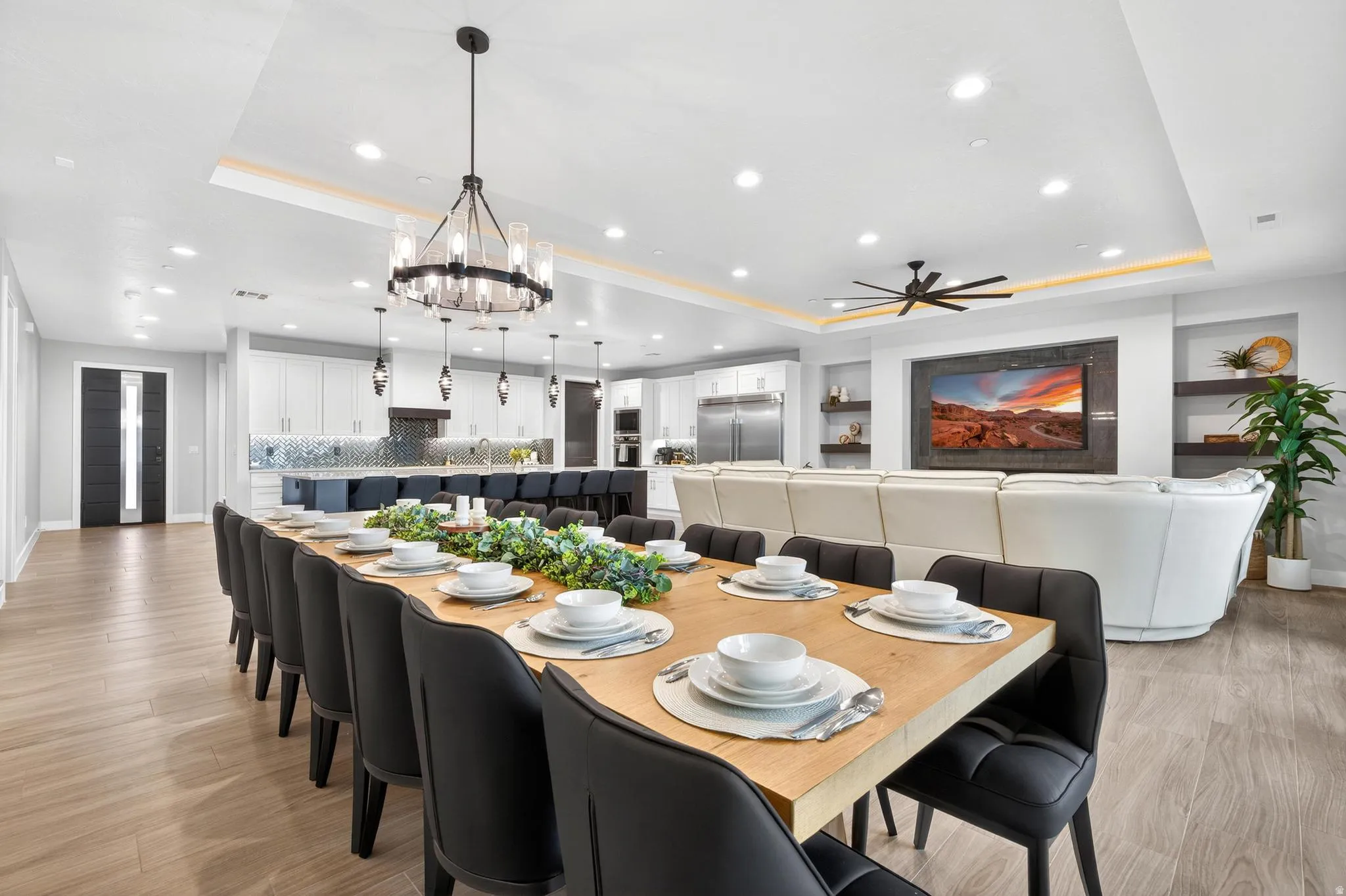 Open-concept interior featuring wood-finish flooring, a contemporary chandelier, recessed lighting, and built-in shelving