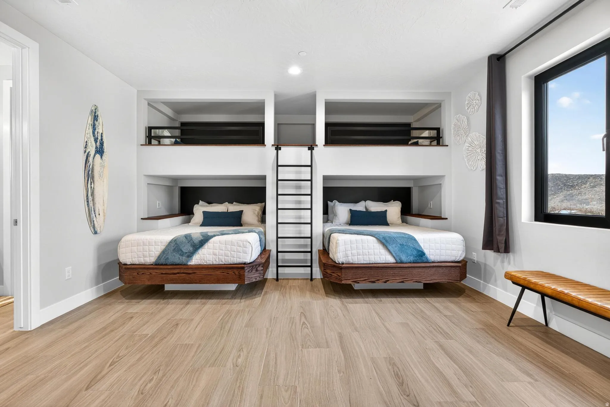Built-in bunk beds with integrated storage, wood-finish flooring, and a large window