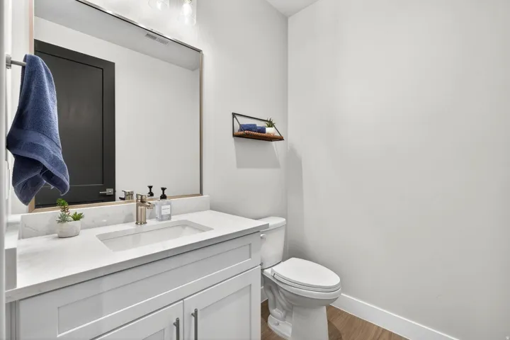 White vanity with shaker-style cabinetry, an integrated sink, and brushed nickel fixtures