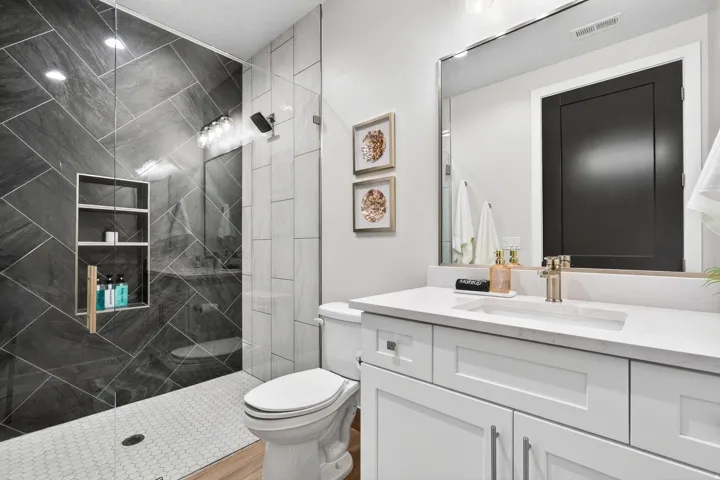 Tiled shower with a built-in niche, glass enclosure, and modern shower fixtures