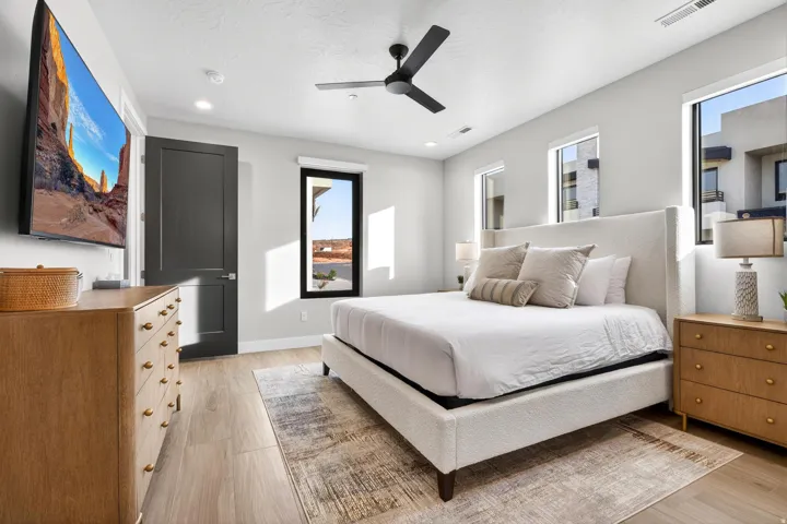Wood-finish flooring, recessed lighting, ceiling fan, and multiple windows with black trim