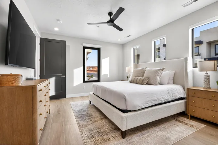 Wood-finish flooring, recessed lighting, ceiling fan, and multiple windows