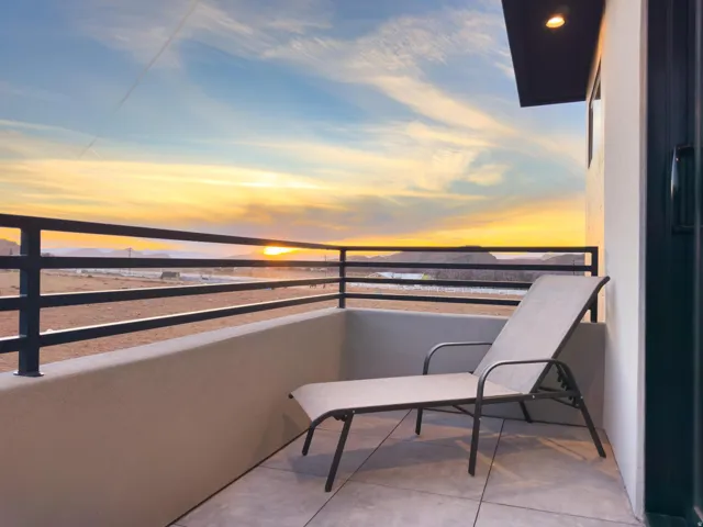 Balcony featuring black metal railings, recessed lighting, and a sliding glass door