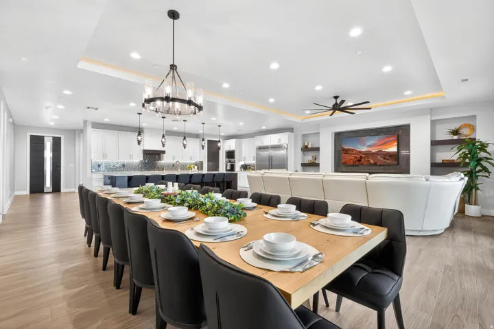 Open-concept interior featuring wood-finish flooring, a contemporary chandelier, recessed lighting, and built-in shelving
