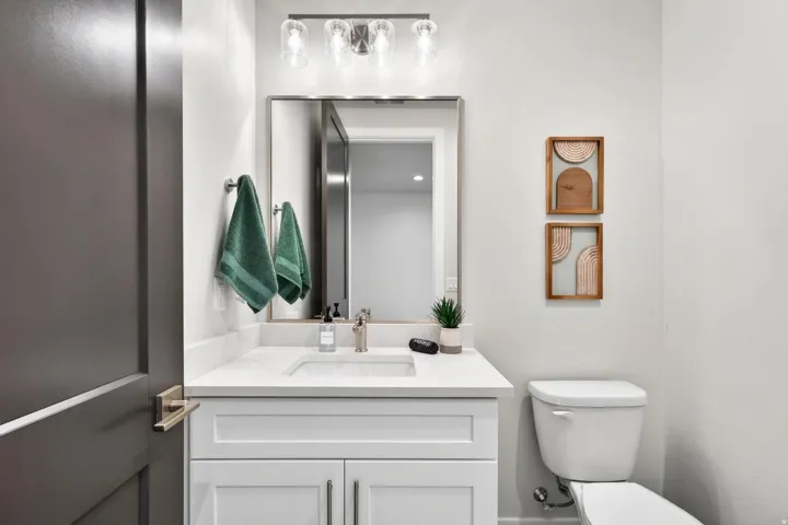 Vanity with an integrated rectangular sink, stone countertop, and brushed nickel faucet