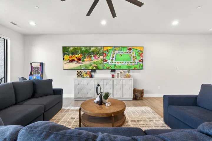 Spacious living area featuring light-toned walls, wood-finish flooring, and recessed lighting