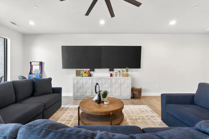 Open-concept living area featuring wood-finish flooring, recessed lighting, and a ceiling fan