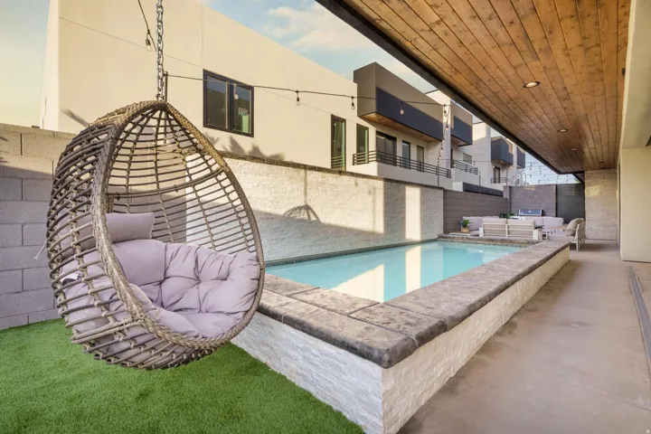 Private outdoor patio featuring a swimming pool, wood-paneled ceiling, and structured hardscaping