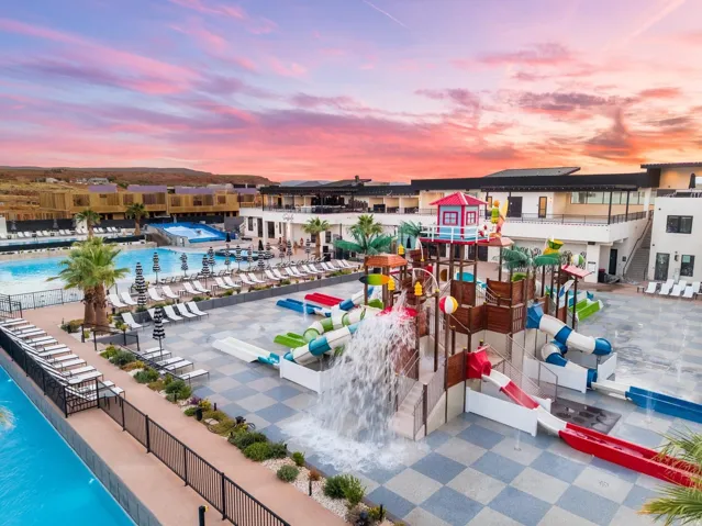 Expansive aquatic recreation area featuring a large pool, multiple water slides, and a splash pad