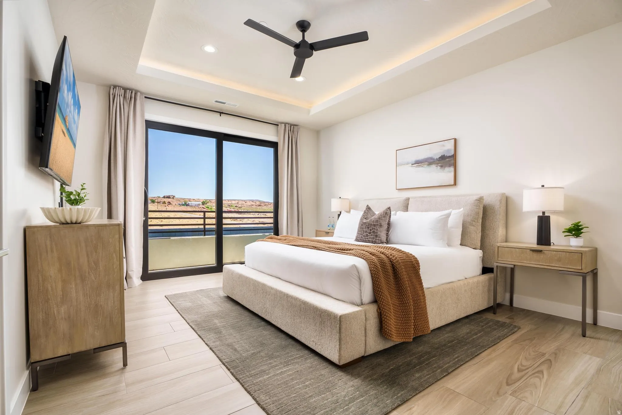 Tray ceiling with recessed lighting, ceiling fan, wood-finish flooring, and sliding glass door leading to a balcony