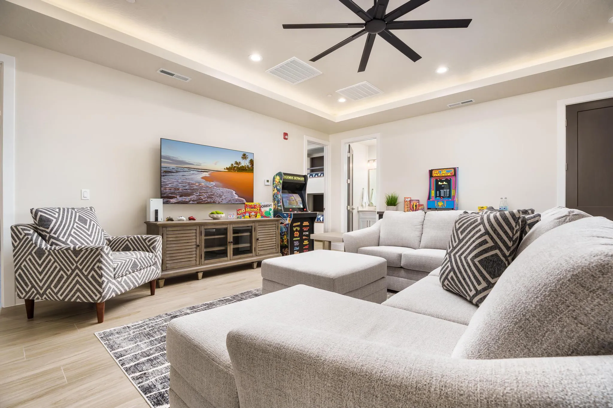 Recessed lighting with tray ceiling, wood-finish flooring, and a contemporary ceiling fan