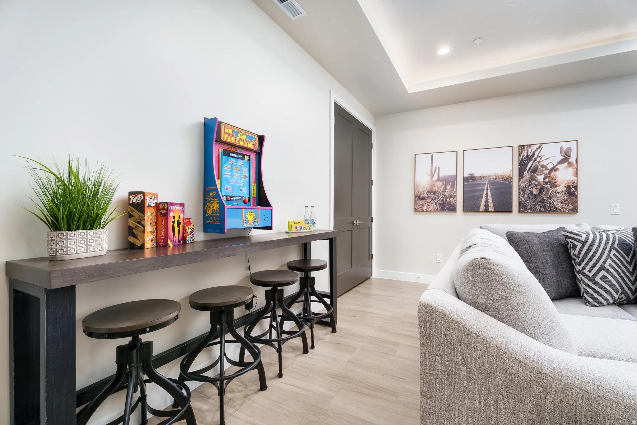 Recessed ceiling lighting, wood-finish flooring, two-panel interior door, tray ceiling, and a built-in console table