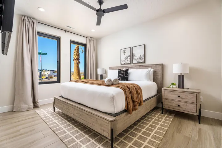 Recessed lighting, ceiling fan, wood-finish flooring, two large windows, and a built-in wall-mounted television bracket