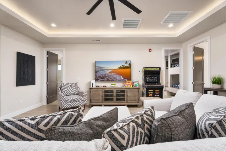 Recessed lighting, ceiling fan, crown molding with accent lighting, wood-finish flooring, and white baseboards