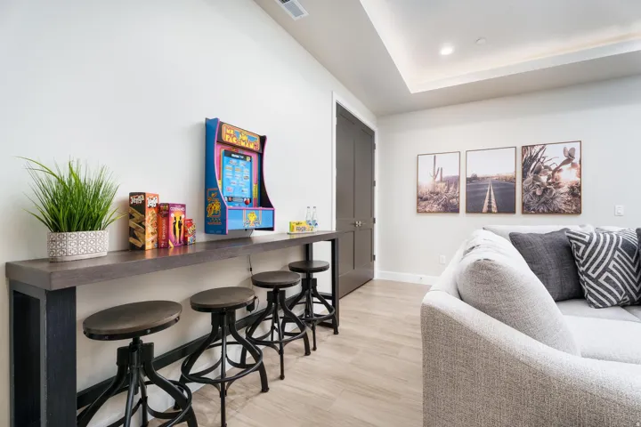 Recessed ceiling lighting, wood-finish flooring, two-panel interior door, tray ceiling, and a built-in console table