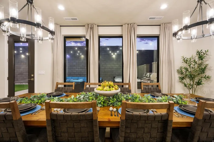 Dining area with recessed lighting, two modern chandeliers, and multiple windows
