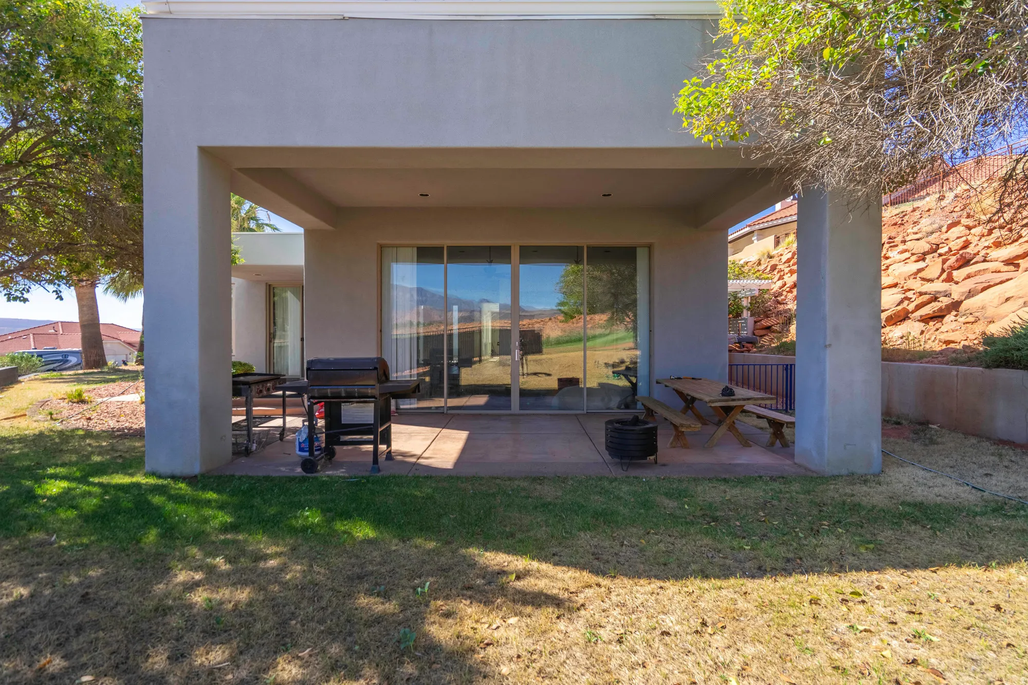 Covered patio with a concrete slab and sliding glass doors
