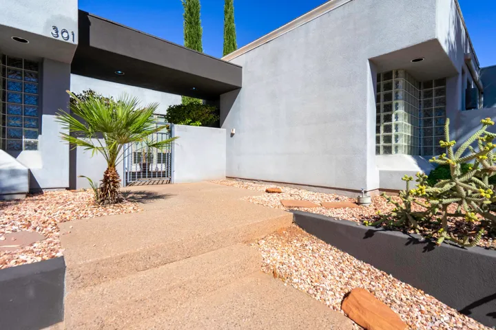 Stucco exterior with glass block windows, a gated entry, and a covered portico