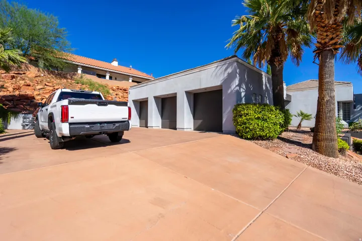 Expansive concrete driveway leading to a three-car garage