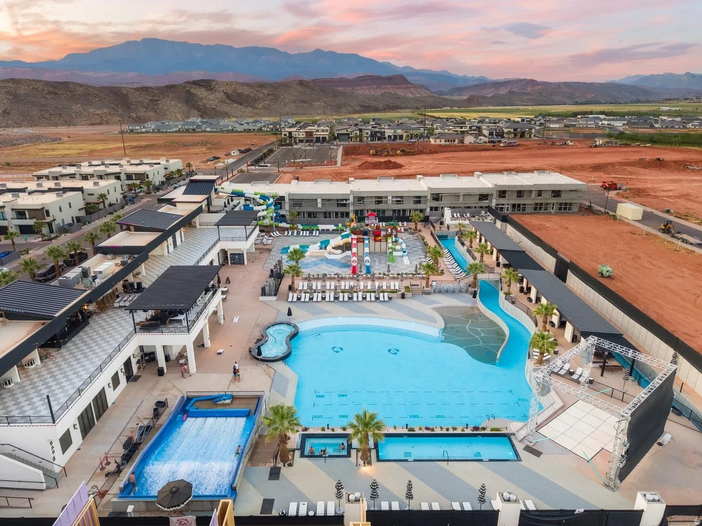 Expansive resort-style pool complex featuring a wave rider, multi-level waterslides, a lazy river, and multiple integrated swimming areas