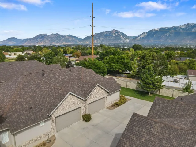 Mountain backdrop with a partially visible roofline, stone facade, and garage doors