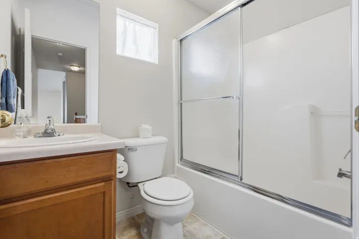 Integrated vanity with single basin sink, wood-finish cabinetry, and neutral countertop