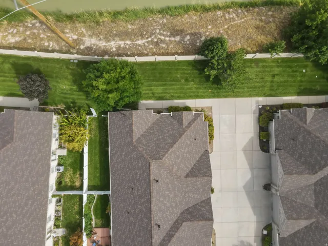 Pitched roofs with asphalt shingles, concrete driveways, and neatly maintained green spaces