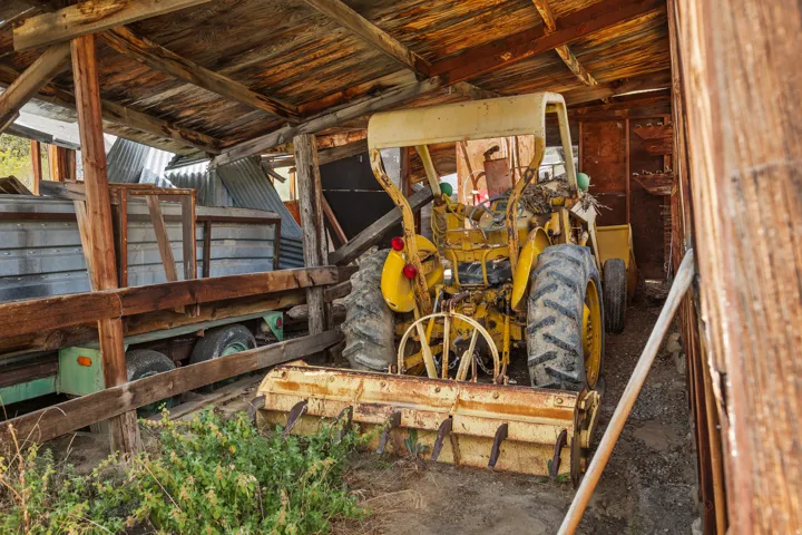 Covered equipment shed with grain bins. Structure is unsafe to enter