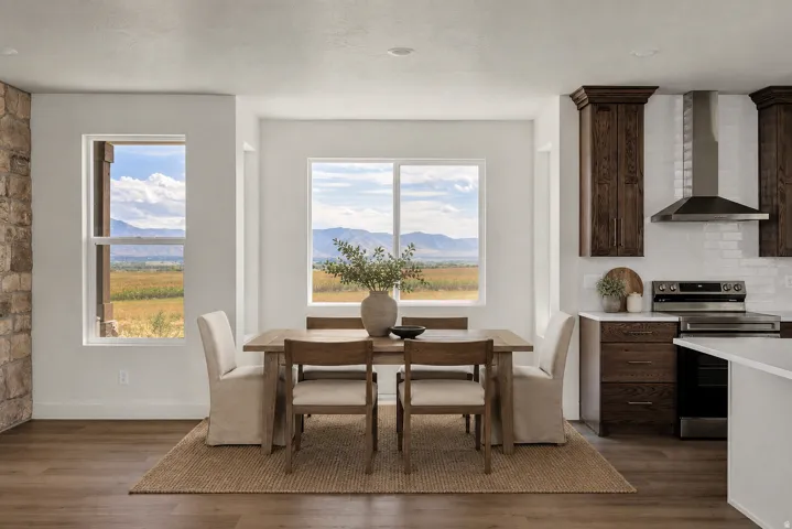 Virtually staged. Expansive windows, wood-finish flooring, stone accent wall, dark wood cabinetry, and a modern stainless steel range hood