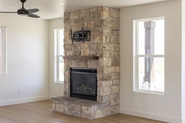 Stone-clad fireplace with a wood mantel and hearth