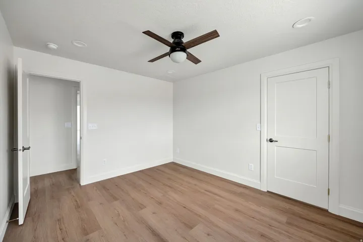 Wood-finish flooring, ceiling fan, recessed lighting, and two-panel interior doors