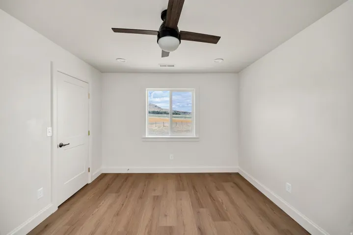 Wood-finish flooring, white walls, and a window with a mountain backdrop