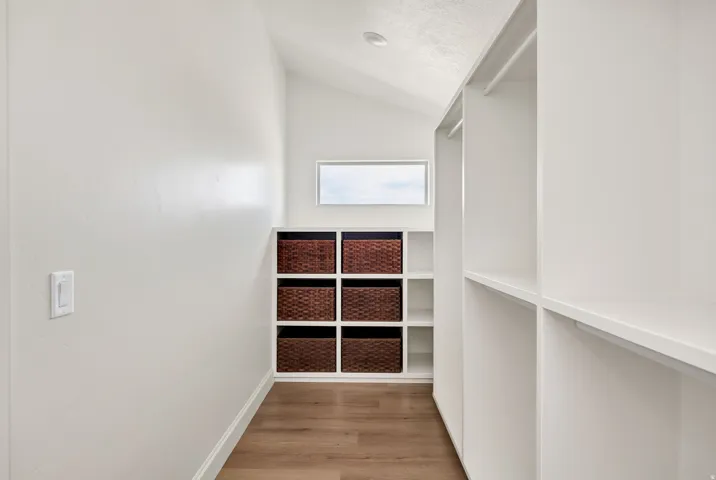 Recessed lighting, wood-finish flooring, built-in shelving, and a horizontal window
